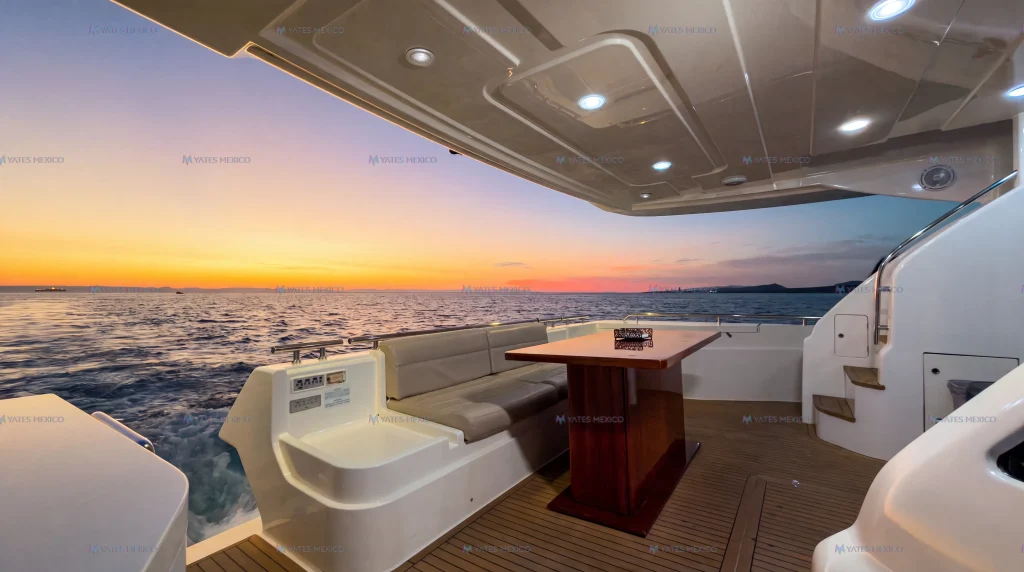 Ferretti 75 yacht charter La Paz - aft deck dining table with sunset over the bay