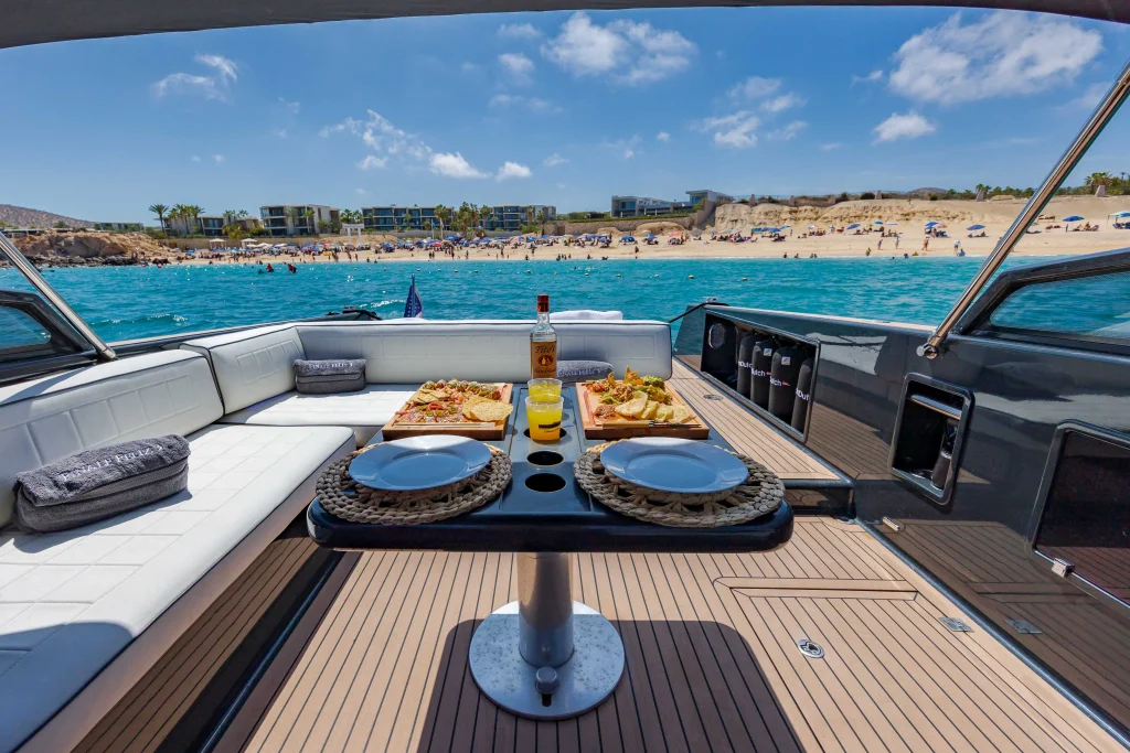 Cockpit table set with food and drinks on the VanDutch 42 off a Los Cabos beach