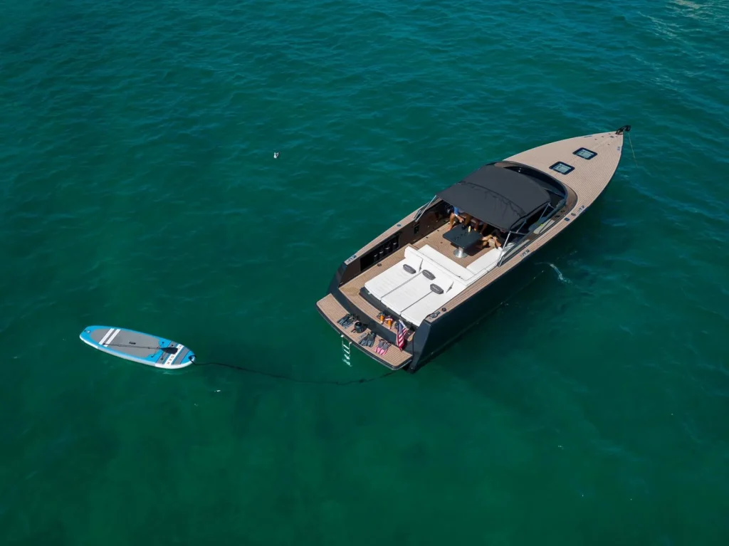 Aerial of the VanDutch 42 at anchor with the paddle board and guests on the sun pad