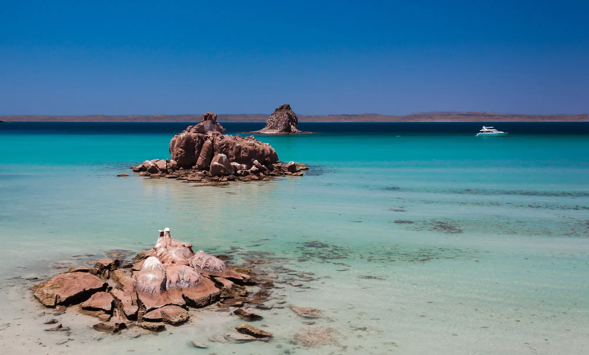 Honeymoon Package 17 Red rock formations and clear turquoise water off Isla Espiritu Santo