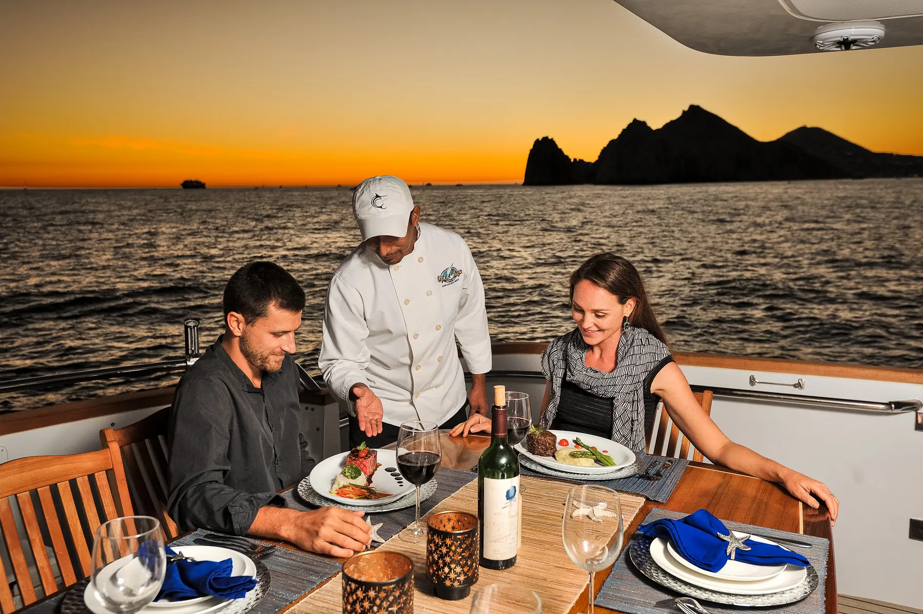 Honeymoon Package 11 Private chef serving a three course dinner on deck at sunset on a YACHTSMX charter